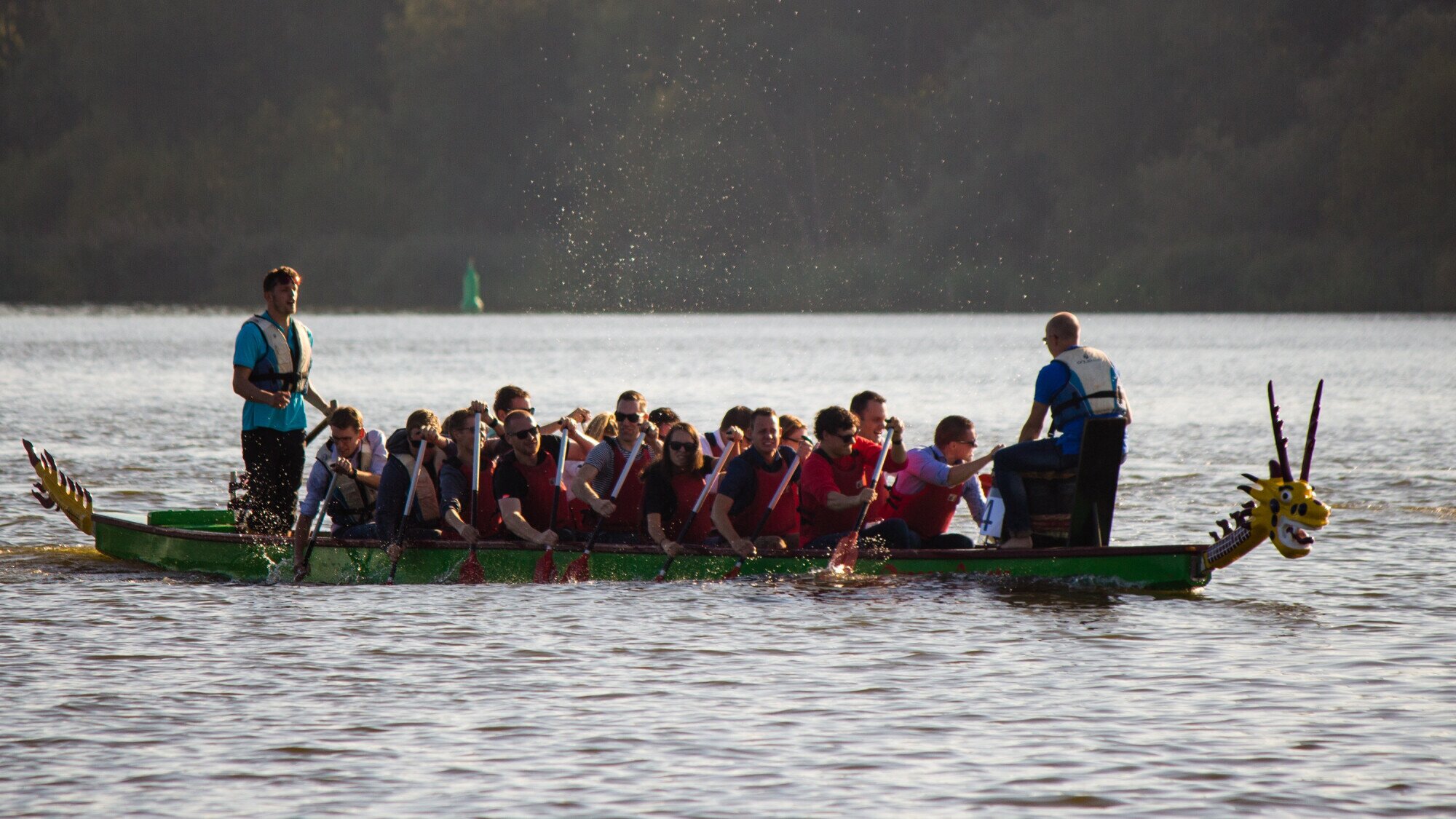 Mensen in een Drakenboot op het water.