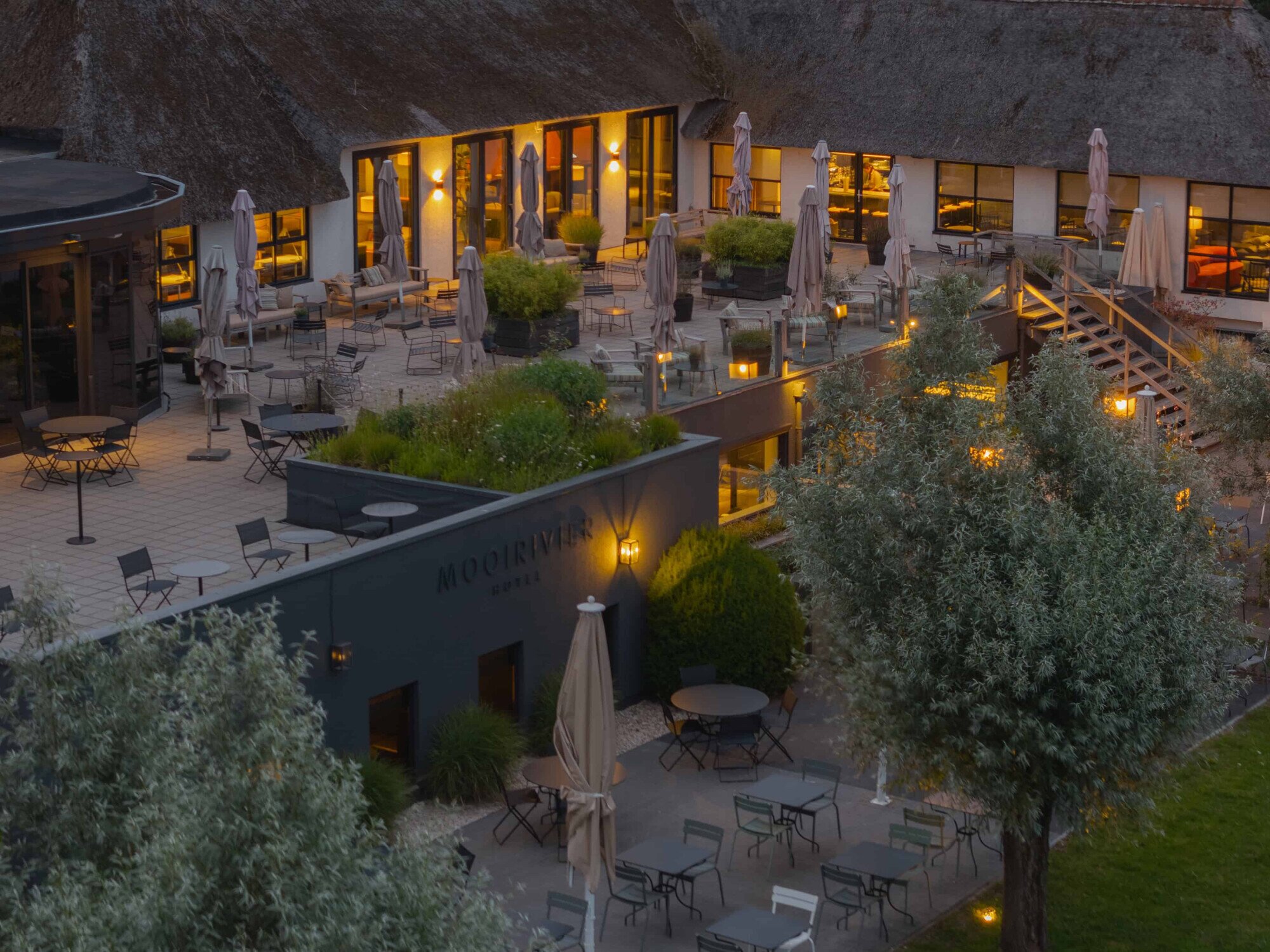 Het ruime terras aan het water met sfeervolle verlichting.