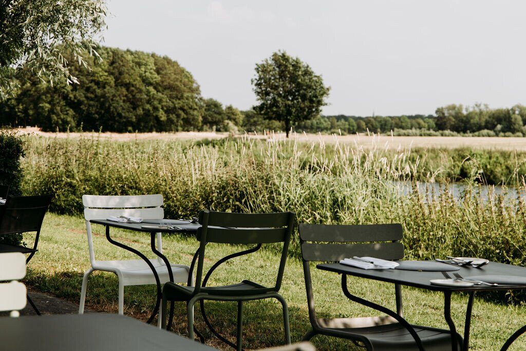 Gedekte tafels op het terras aan het water.