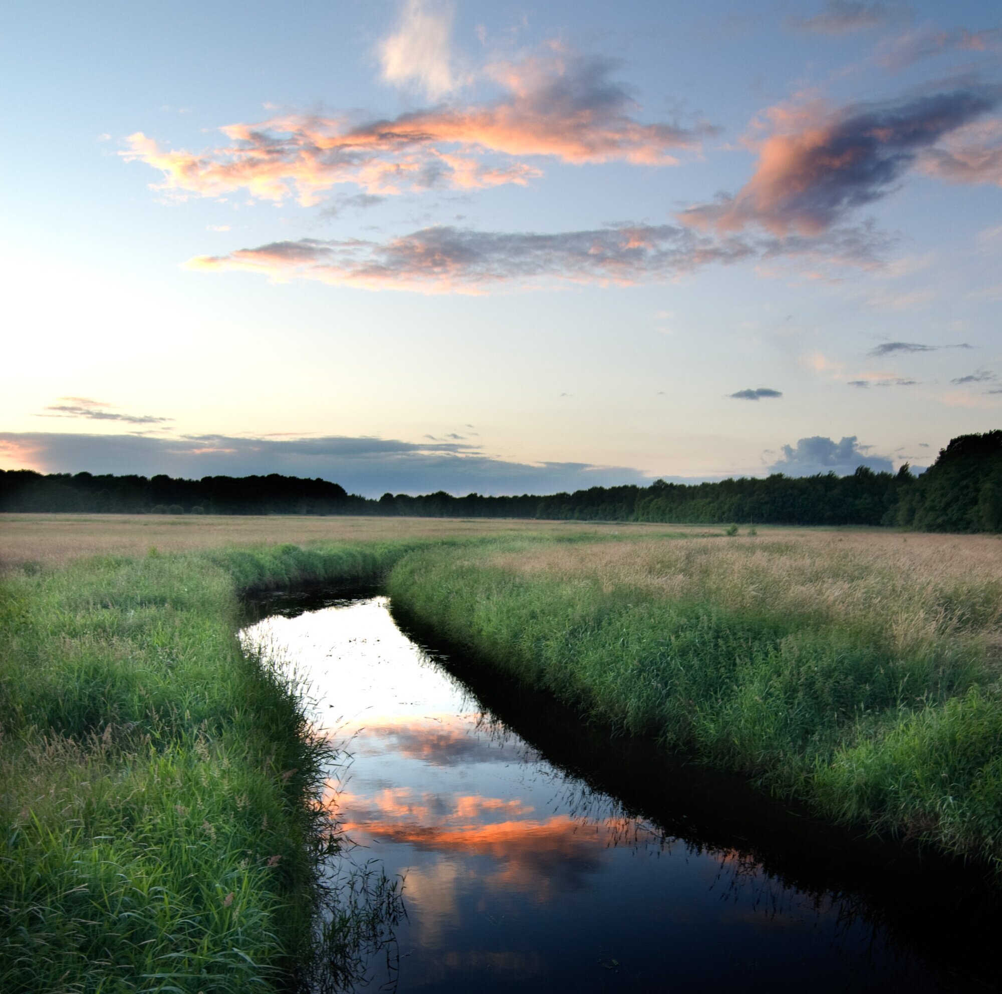 Zonsondergang in het water langs de graslanden van het Vechtdal.