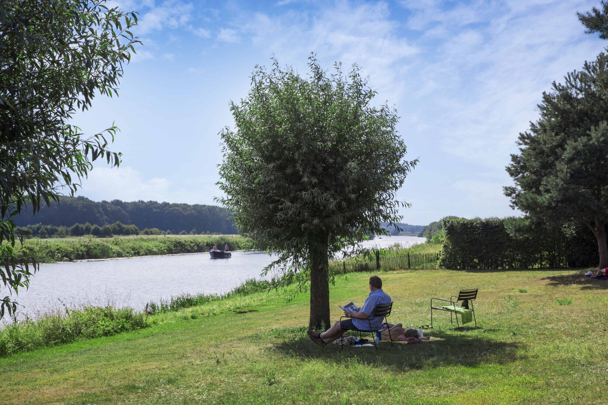 Persoon onder boom aan de Vecht.